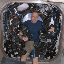 NASA Astronaut Don Pettit on board the ISS holding one of the cameras modified by Spencer's Camera & Photo.